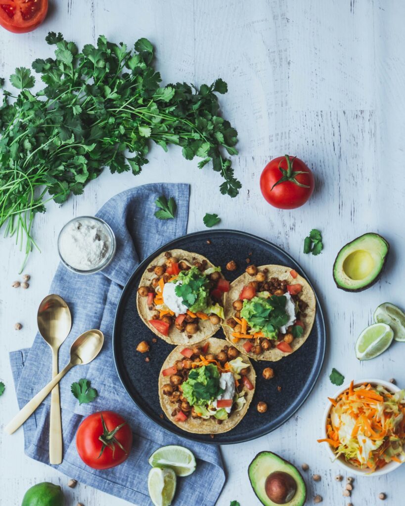 pizza with green leaves and red tomato on black ceramic plate tacos jackfruit